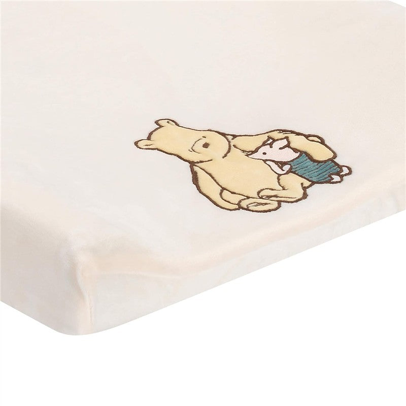 Disney Storytime Pooh Changing Pad Cover featuring Pooh Bear and Piglet in a warm hug on a soft, cream background.