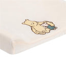 Disney Storytime Pooh Changing Pad Cover featuring Pooh Bear and Piglet in a warm hug on a soft, cream background.