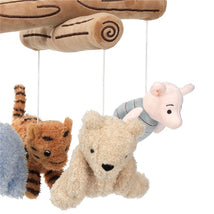 Disney Storytime Pooh musical mobile featuring plush characters: a tiger, bear, and pig, suspended from a decorative wooden branch.