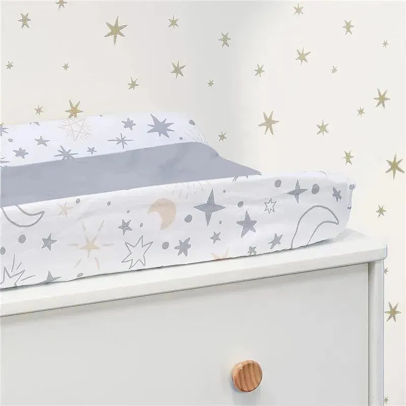 Changing pad covered with a Lambs & Ivy Goodnight Moon design featuring stars and moons, resting on a white dresser.