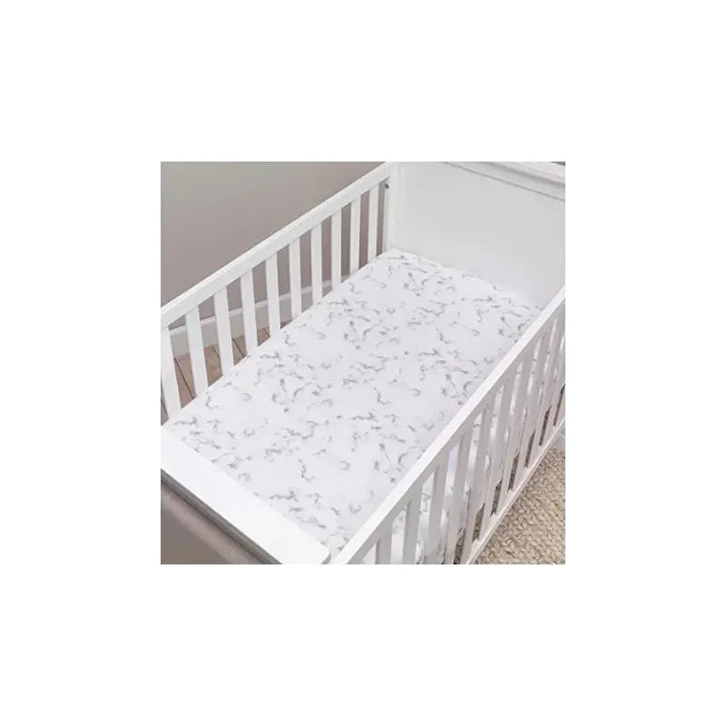 Gray marble-patterned fitted sheet in a white crib, showcasing its design on a soft surface.
