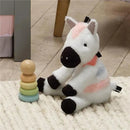Plush zebra toy from Lambs & Ivy, featuring white fabric with pink and brown accents, beside a colorful stacking toy.