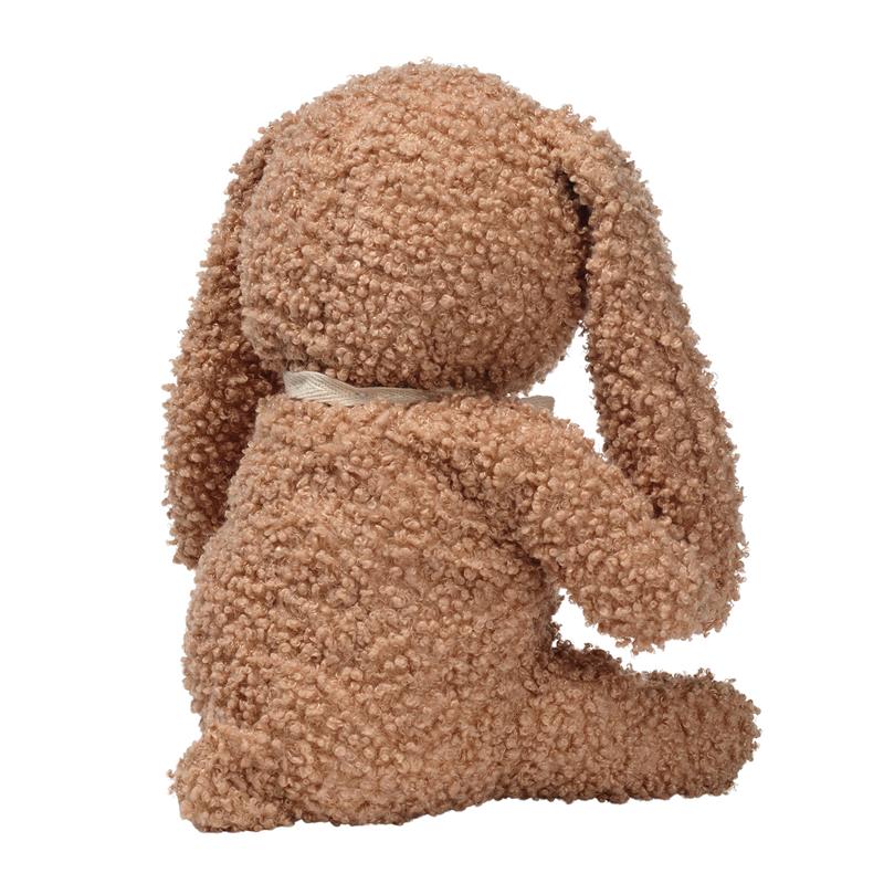 Organic cotton bunny plush in honey color with curly texture, facing away and wearing a small ribbon around its neck.