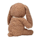 Organic cotton bunny plush in honey color with curly texture, facing away and wearing a small ribbon around its neck.