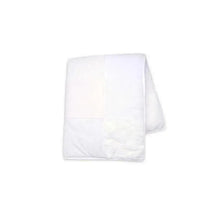 White patchwork quilt by Lambs & Ivy, featuring various white fabric patterns and textures, folded neatly.