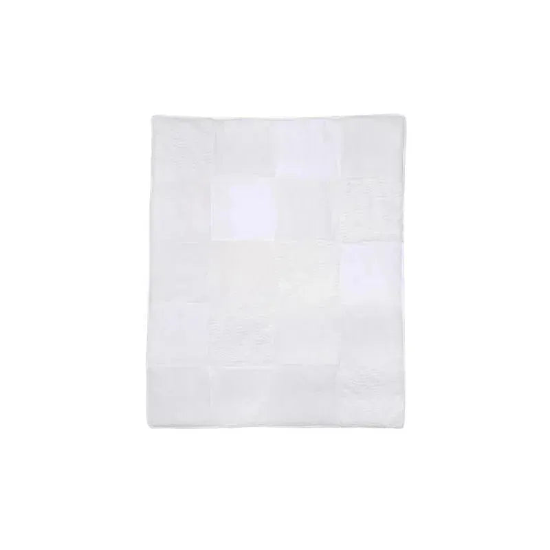 Soft white patchwork quilt featuring a variety of textured squares, ideal for nursery decor.
