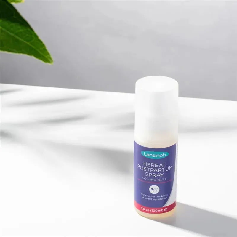 Lansinoh Herbal Postpartum Spray bottle on a surface, labeled for cooling relief with 3.3 oz (100 ml) content.