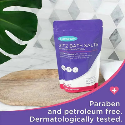 Lansinoh Sitz Bath Salts 10 oz, purple pouch on wooden surface, promotes postpartum recovery with natural ingredients.