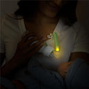 Latchlight Wearable Baby Night Light illuminating a bottle held by a parent feeding a baby in a dimly lit room.