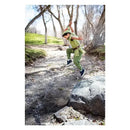 Child wearing a green Peter Pan costume with a red hat jumps over a rock in a natural outdoor setting.