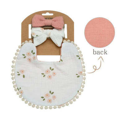 Floral cotton baby bib with pom-pom trim and two matching headbands in a packaged set.