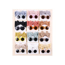 Baby sunglasses and headbands set in various colors, featuring large bows and round lenses, displayed on packaging.