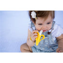 Infant using a yellow Baby Banana Brush, designed for teething, with a textured end for soothing gums.