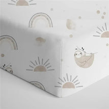 100% cotton crib fitted sheet featuring playful sloth and rainbow patterns in soft, neutral colors.