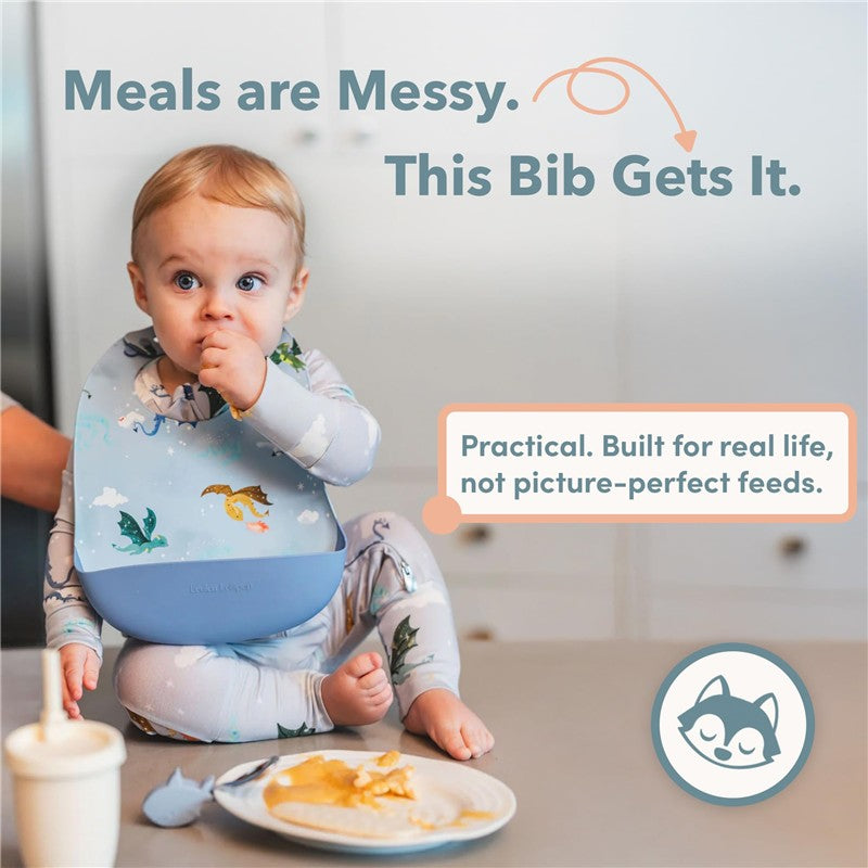 Silicone bib featuring a unicorn ballet design worn by a baby, seated at a table with food.