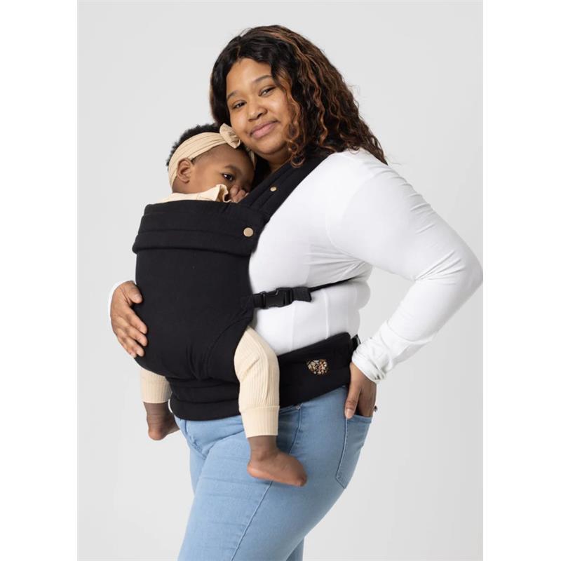 Mabe Monarch Carrier in ebony worn by a smiling woman holding a baby, both comfortable and secure against her body.