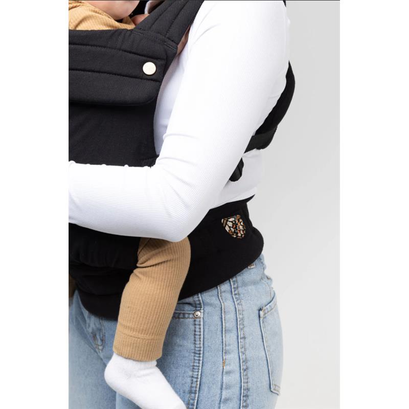 Mabe Monarch Carrier in Ebony, worn by a parent holding a child, showcasing fabric details and a side pocket.