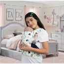 Maternity doll carrier featuring a girl holding a baby doll, both in a dinosaur-patterned wrap, in a pastel room setting.