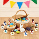Assorted Macrobaby Little Jesus figurines with colorful Easter eggs and a white rabbit in a festive setting.