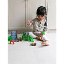 Child playing with Magnatiles Forest Animals set, featuring green trees and animal figures on a floor.