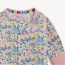 Colorful floral patterned convertible coverall with pink trim and a rainbow-striped neckline.