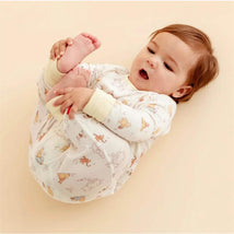 Infant in a Dumbo-themed modal coverall, playfully reaching for their feet against a light background.
