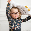 Child wearing Harry Potter-themed long sleeve pajamas, holding a fluffy white blanket with owl features.