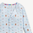 Blue modal convertible coverall featuring an assortment of cute nursery-themed illustrations, including teddy bears and baby items.