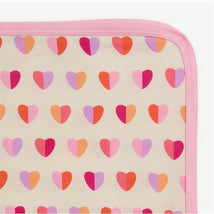 Pink Xoxo modal baby blanket featuring a pattern of colorful hearts on a beige background with a pink border.