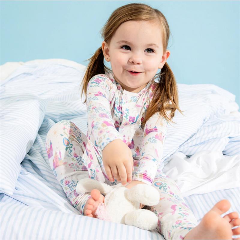 Toddler in a floral-patterned modal convertible coverall, playfully holding a stuffed bunny on a bed.