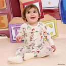 Baby wearing a Toy Story-themed modal coverall featuring characters like Woody and Jessie, sitting against a colorful block backdrop.