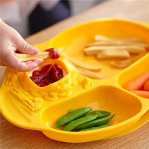 Toddler dining set featuring a bright yellow divided plate with fries, carrots, snap peas, and a portion for ketchup.