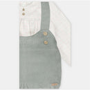 Short-sleeved checkered shirt and green woven shorts with shoulder straps, featuring wooden buttons and a label.