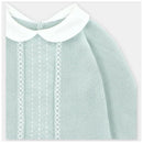 Pastel blue knit sweater with a white collar, featuring textured patterns and decorative details on the front.