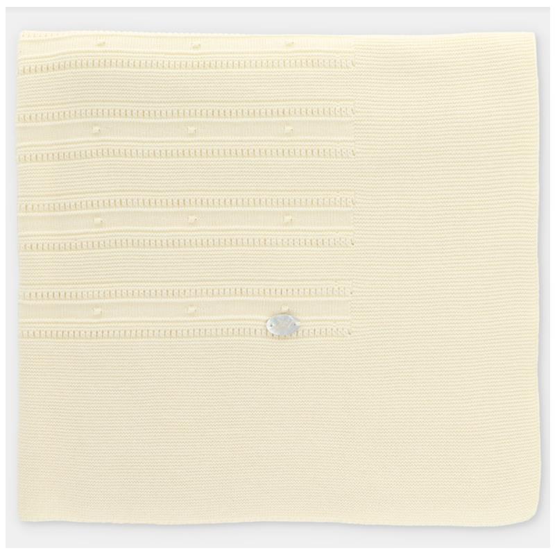 Knit baby blanket in creamy white with textured patterns and a silver label, designed for warmth and comfort.