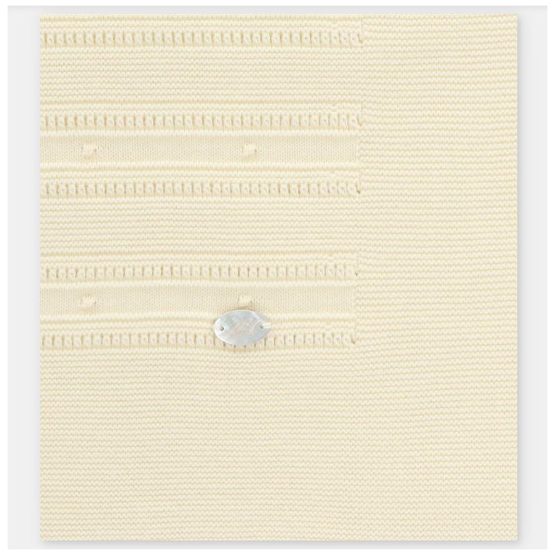 Knit baby blanket in soft cream color with textured stripes, featuring a small silver tag.