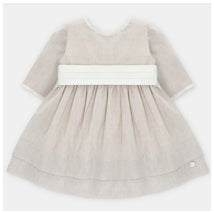 Beige baby girl dress by Martin Aranda featuring a pleated skirt, long sleeves, and a white waistband.