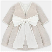 Beige baby girl dress by Martin Aranda featuring a white bow at the waist and lace trim on the sleeves.