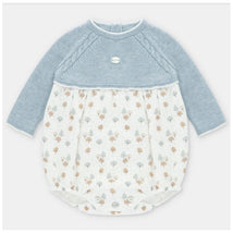Knit and woven short romper for baby girls featuring a blue top and a patterned bottom with trees and a button closure.