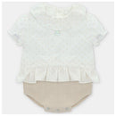 Baby short romper by Martin Aranda in Volterra, Arena with a white dotted top and beige knitted bottom.