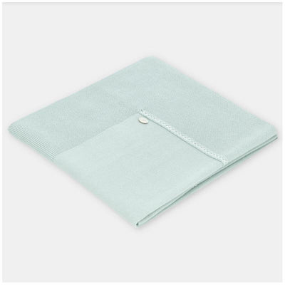 Light pink Martin Aranda blanket, knitted design with a smooth texture, featuring a decorative button detail.