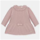 Dusty rose knitted dress featuring a ribbed design, rounded collar, long sleeves, and a bow detail at the waist.