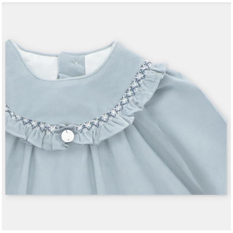 Dress in blue-grey fabric featuring a ruffled collar and decorative stitching, with a button closure at the back.