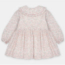Light pink dress with an all-over floral print, long sleeves, and a ruffled collar.
