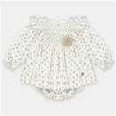 Woven beige dress and bloomer set with tree patterns and a decorative pom-pom, suitable for children.