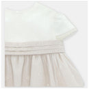 Beige linen dress with a white top and layered tulle skirt, featuring delicate embroidery details.