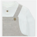 White shirt with a beige overall featuring wooden buttons, designed for casual wear.