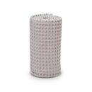 Waffle blanket in sand color, rolled up, showcasing textured fabric, ideal for comfort and warmth.