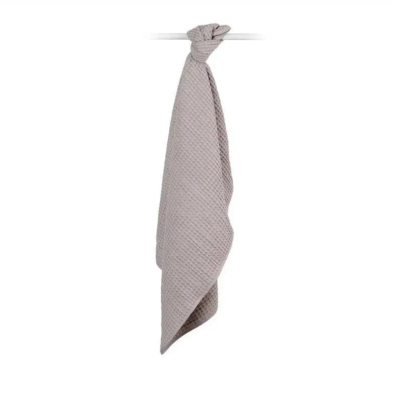 Waffle blanket by Mary Meyer in sand color, hanging with a knotted top, showcasing a textured surface.
