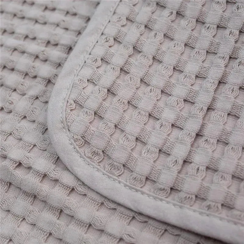 Waffle texture of the Mary Meyer Lulujo blanket in sand color, featuring a smooth, rounded edge.